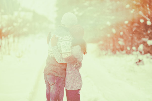 一对相爱的年轻夫妇在冬天的日落户外拥抱图片下载