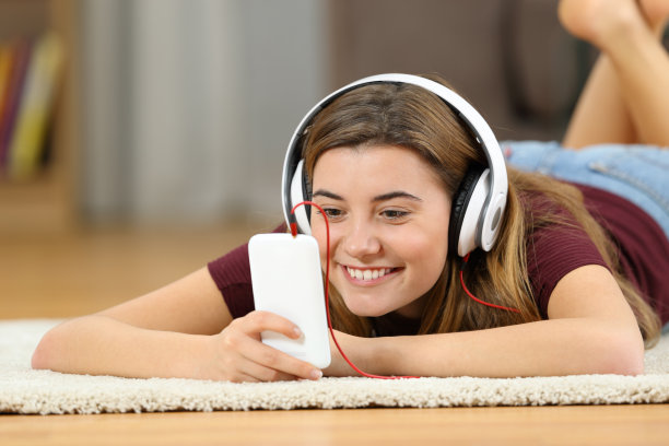 快乐的青少年在家里用智能手机看媒体图片下载