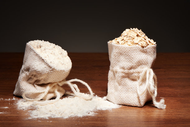 黑色的桌子上放着麻袋面粉和燕麦片图片下载