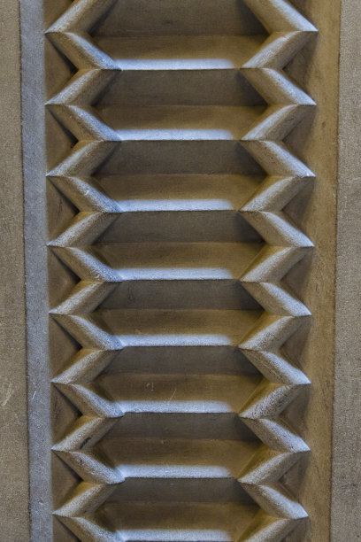 抽象的背景。垂直的石头与波浪形图案雕刻图片下载