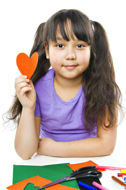 女孩从图画纸上剪下了心形图片下载