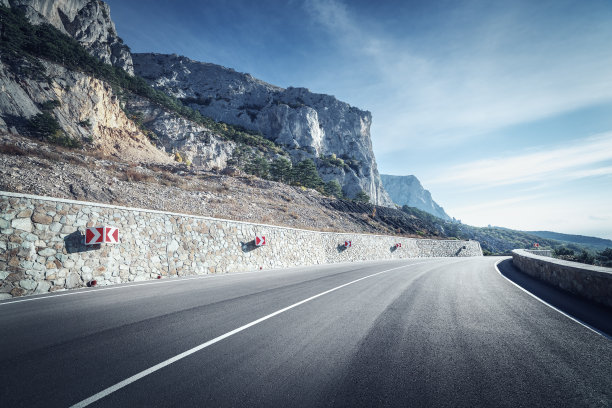 日出时分的秋日森林里的柏油路。克里米亚半岛的山脉图片下载