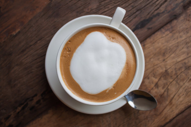 木桌上放着一杯卡布奇诺图片下载