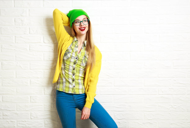 快乐的嬉皮士女孩在白砖墙背景图片下载