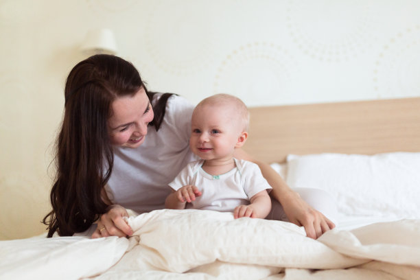 婴儿和妈妈在床上玩毯子，图片下载