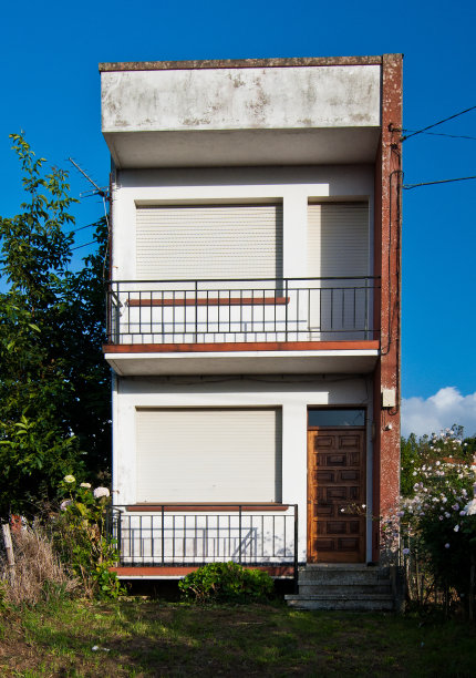 垂直两层狭窄的砖房子与阳台图片下载