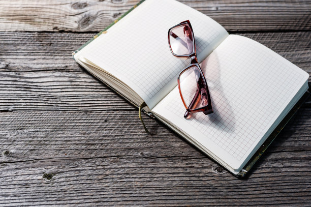 笔记本打开空白，眼镜放在木桌上图片下载