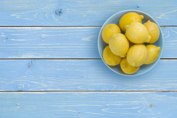 顶部视图的柠檬在蓝色的盘子在热带背景素材图片