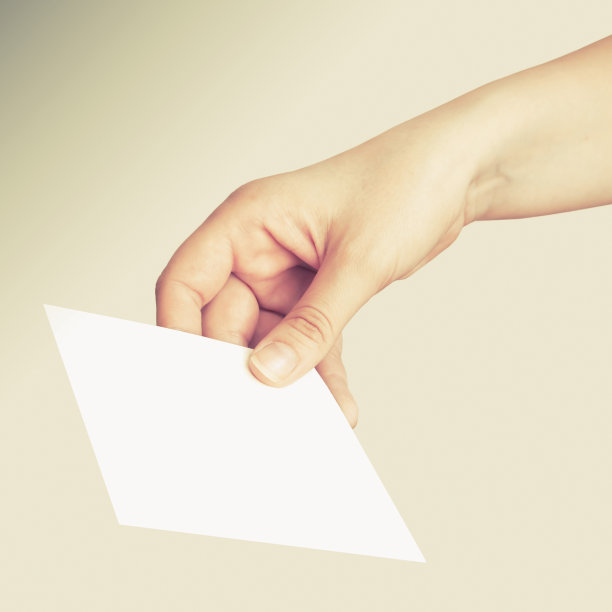 灰色背景上白色卡片的女性手图片下载