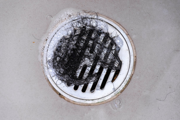 洗澡时头发在浴缸排水管里结块。图片下载