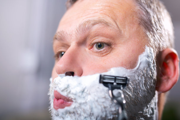 中年男子在浴室里刮胡子图片下载