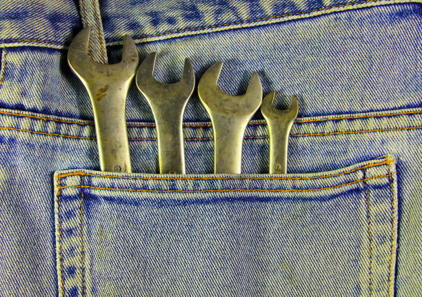 蓝色口袋牛仔裤里的扳手工具图片下载