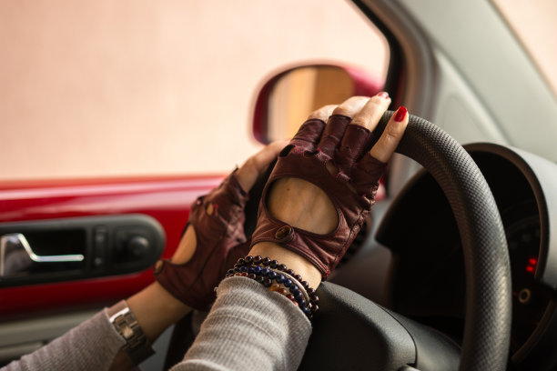 女性手戴手套驾驶方向盘机器图片下载