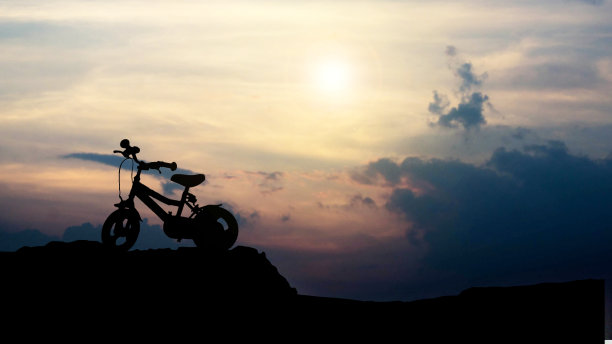 一辆儿童自行车的剪影在一个彩色的日落图片下载