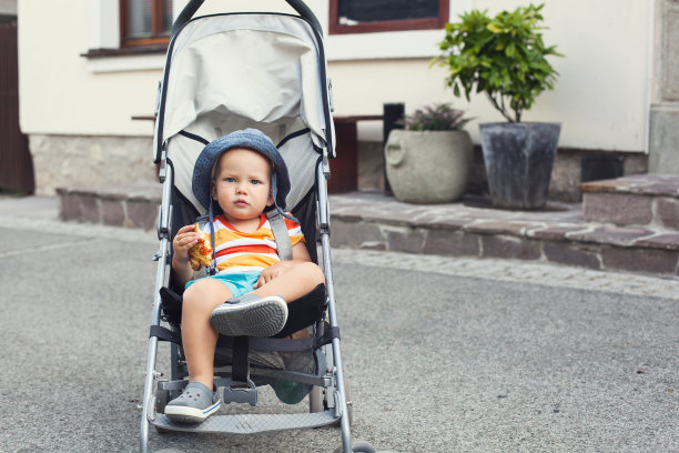 街上可爱的婴儿车里蹒跚学步的孩子。图片下载
