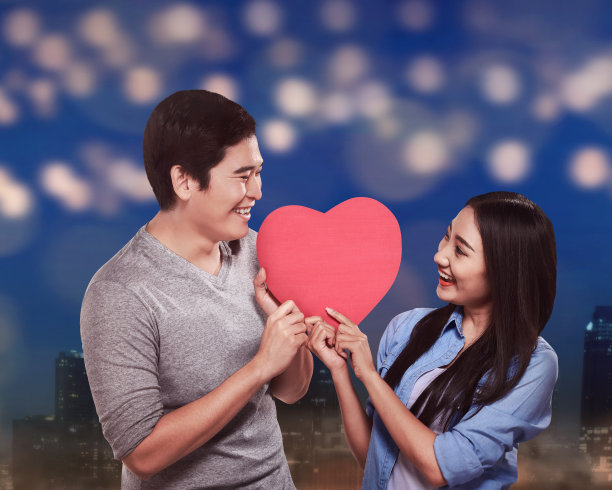 亚洲夫妇抱着红色的心形状素材图片