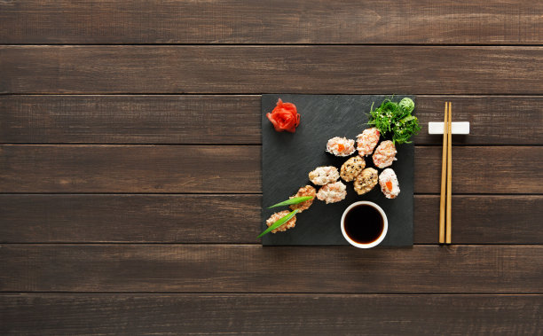 一套寿司maki和卷在黑色的乡村木材图片下载