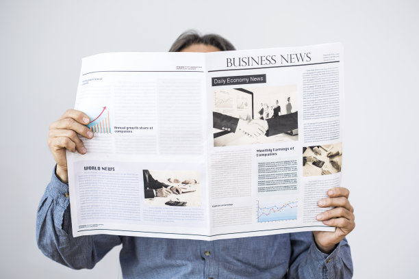 在灰色的背景下，一个男人拿着报纸看图片下载