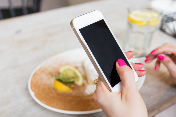 一个女人在咖啡馆拿着手机图片下载