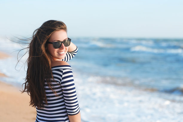 美丽的女孩放松和微笑的户外夏天的海滩图片下载