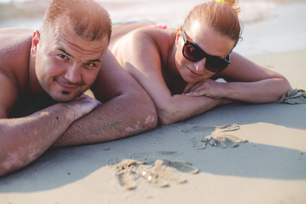 一对夫妇躺在沙滩上图片下载