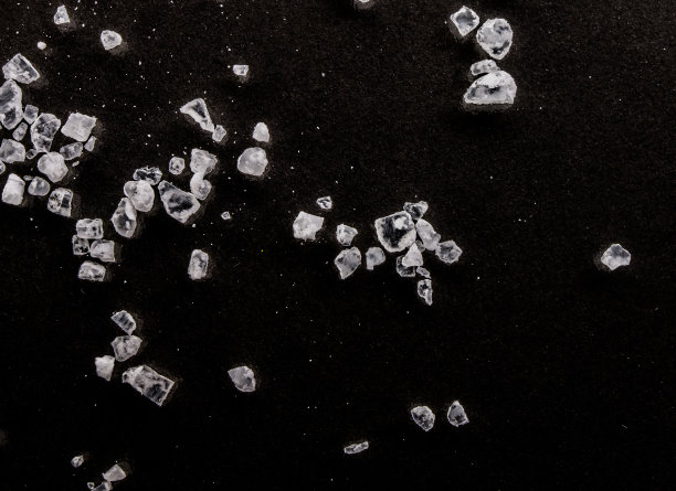 黑色背景微距上的盐粒图片下载