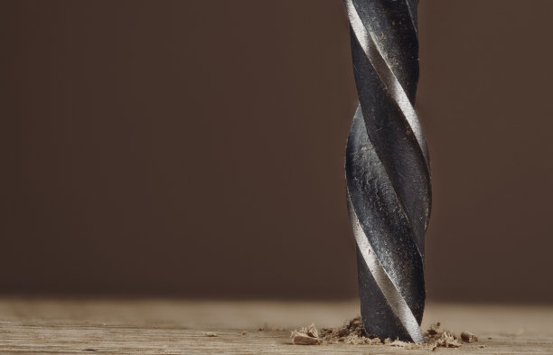 深色旧钻头在木板上钻孔图片下载