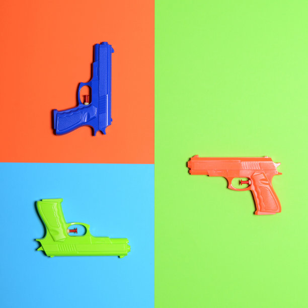 彩色背景上的玩具手枪-最小设计俯视图图片下载