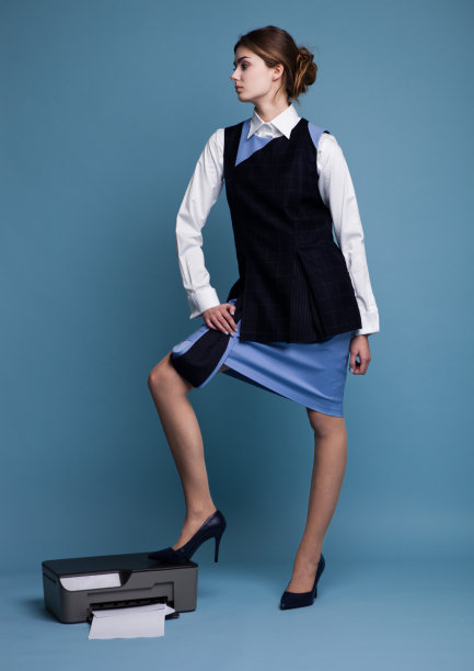 穿着工作服的女商人站在打印机上图片下载