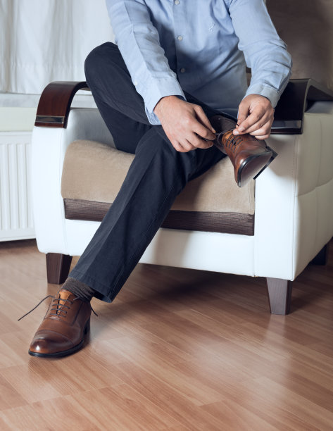 男人系着他的棕色鞋子图片下载