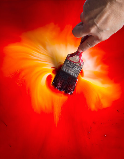 男人用刷子涂红色和黄色颜料图片下载