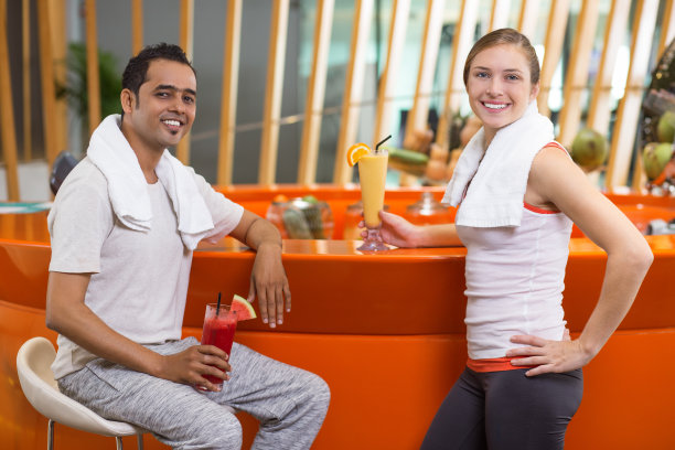 微笑的男人和女人在运动酒吧冰沙图片下载