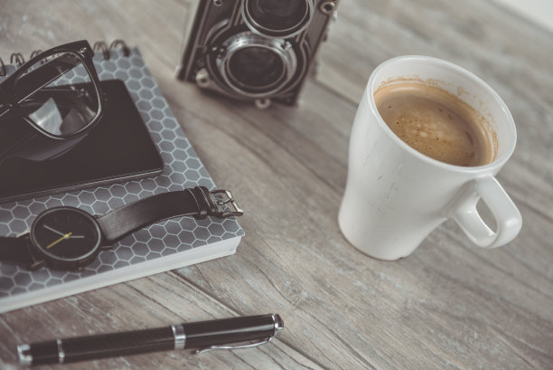 咖啡和个人物品放在桌面上图片下载