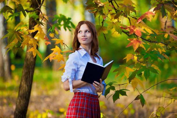 穿着红裙子，白衬衫和书的女学生图片下载