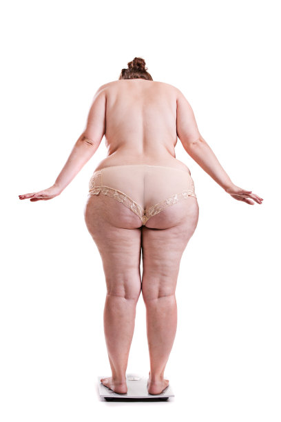 体重秤上有肥胖的年轻女人图片下载