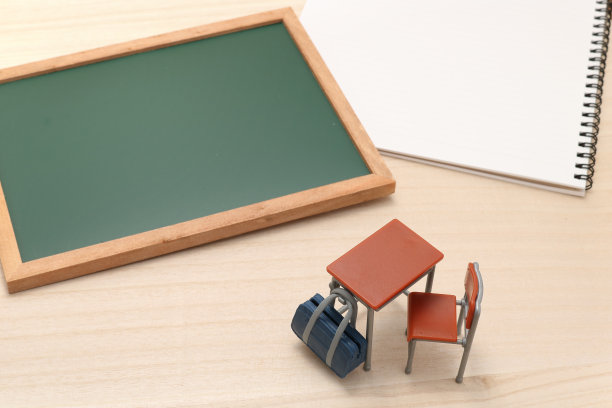 黑板、笔记本、课桌和书包放在木头上。图片下载