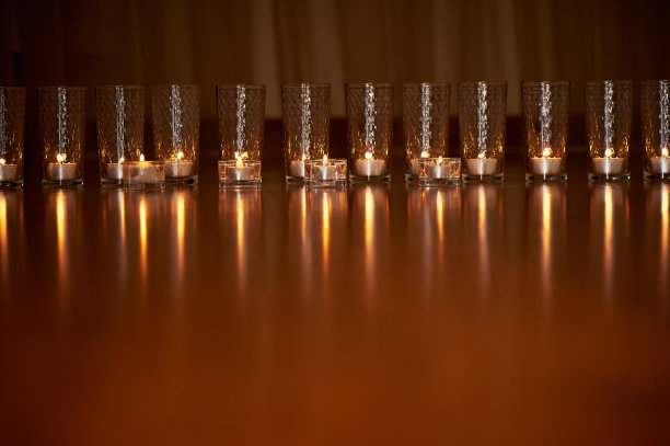 燃烧的蜡烛在透明的玻璃上，闪亮的地板，反射。情绪图片下载