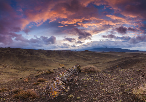 五颜六色的日落在岩石草原上。蒙古。图片下载