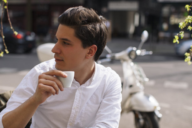 帅哥在户外的咖啡馆里喝咖啡图片下载
