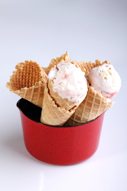 白色背景下的红色金属锅里的甜筒冰淇淋图片下载