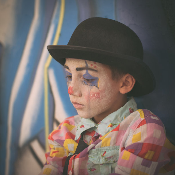 忧郁的孩子装扮成小丑图片下载