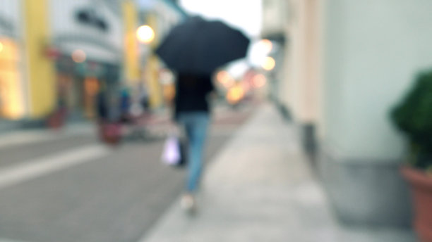 身材苗条的黑发女孩用雨伞把她买的东西带了进来图片下载