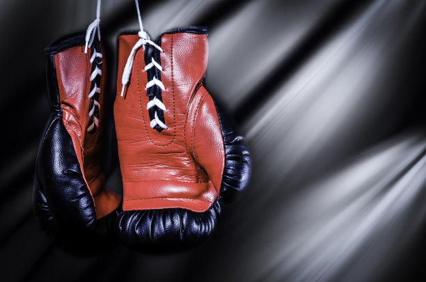 红色和黑色拳击手套，黑色背景与光线图片下载