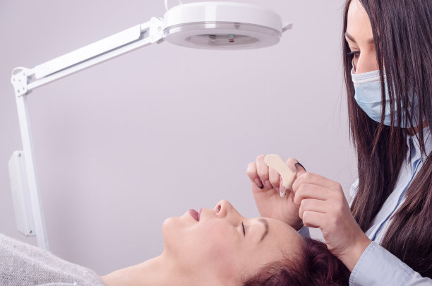 病人躺在桌子上做面部护理图片下载