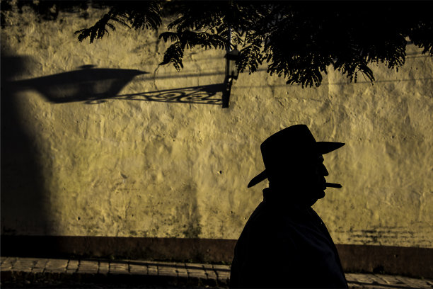 殖民时期的芥末墙旁，古巴牛仔抽着雪茄图片下载