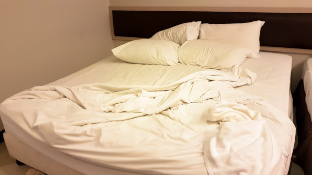 房间里有枕头和毯子的脏床图片下载