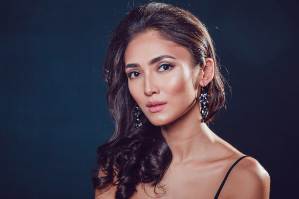 黑发女孩，有着闪亮的卷发和漂亮的耳环图片下载