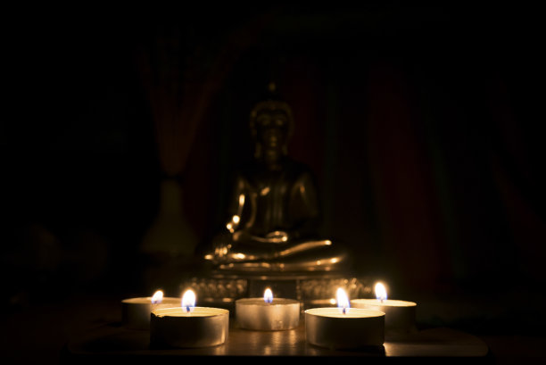 烛光与模糊佛像。图片下载