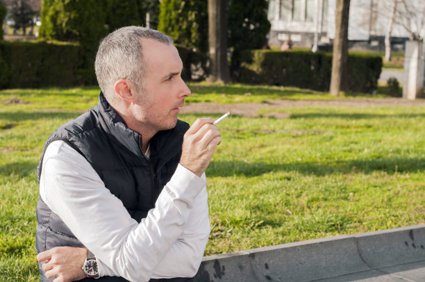 坐在人行道上抽烟的商人图片下载