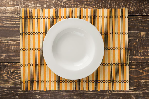 白色空盘子竹编织和木制桌子背景在顶视图图片下载